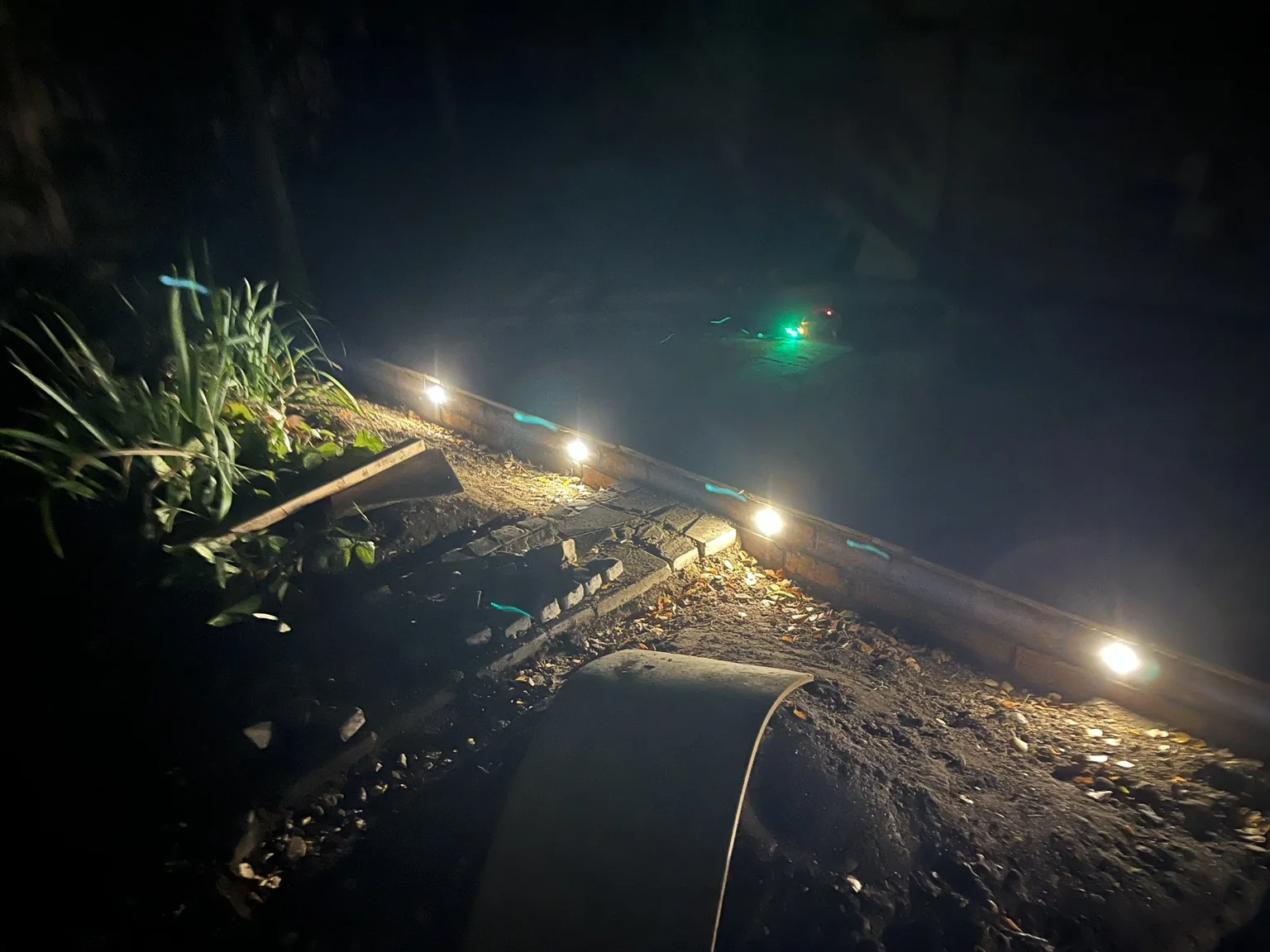 Finished brick-faced patio edge with warm-white lights glowing at night